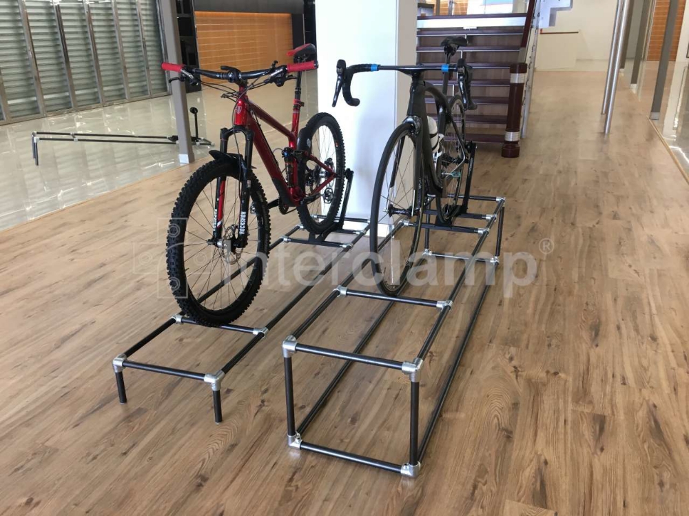 Black powder-coated Interclamp key clamp fittings forming a custom bike rack, demonstrating a combination of functionality and aesthetic appeal.